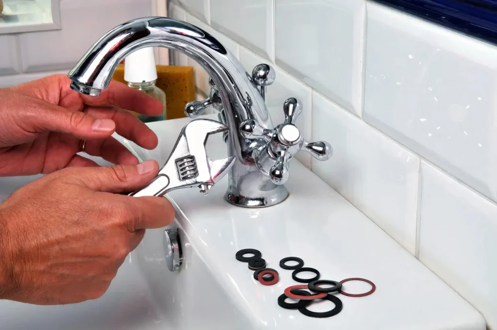 Plumber performing maintenance on a bathroom faucet in Lafayette