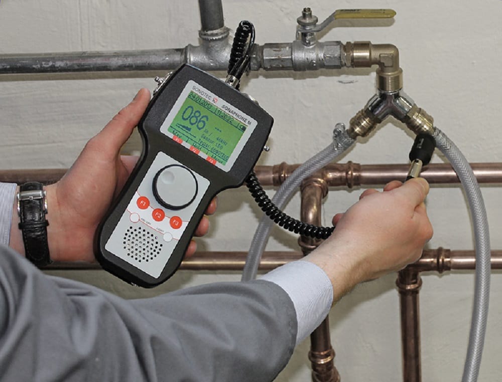 Plumber testing pipes with electronic leak detection equipment in Lafayette