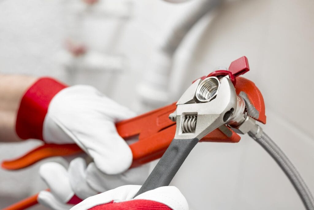 Plumber holding pipe wrenches for an emergency repair in Lafayette