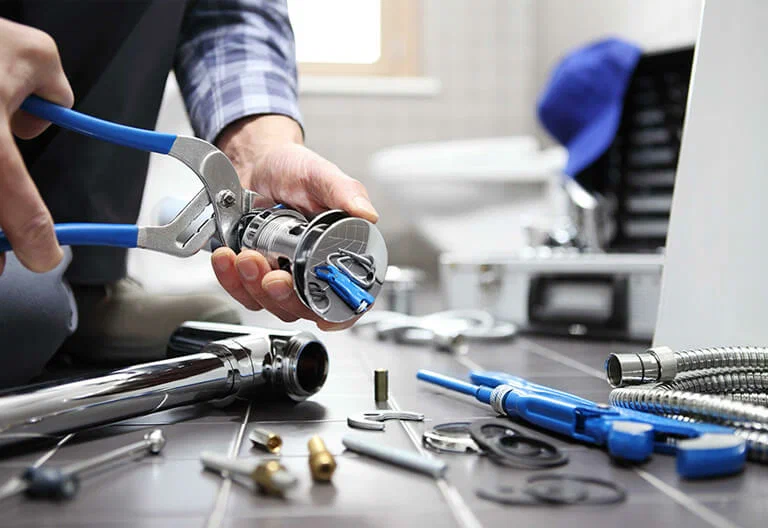 Technician repairing a plumbing fixture with professional tools in Lafayette