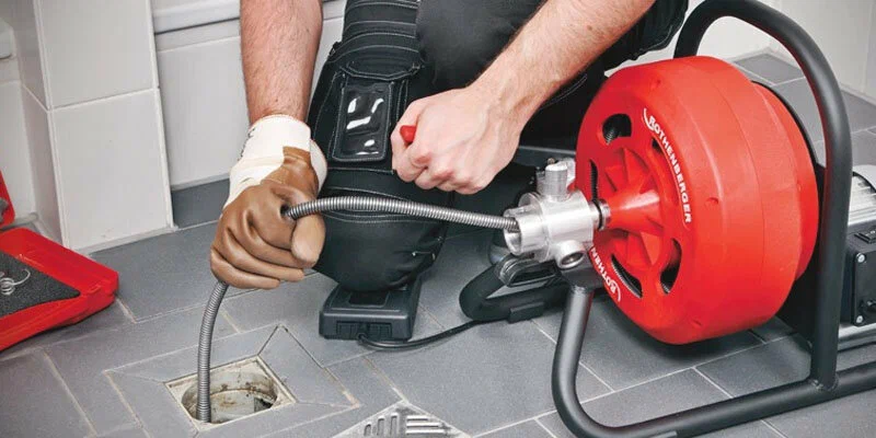 Plumber using a drain-cleaning machine in Lafayette