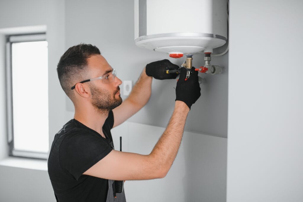 Technician performing water heater maintenance in Lafayette